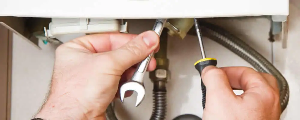 Boiler repair technician tightening pipe fittings and connections in Madison, WI