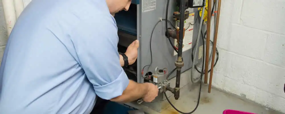 Furnace repair technician inspecting and servicing a home heating system in Madison, WI