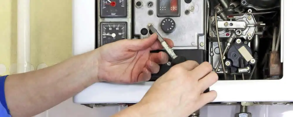 Heating repair technician adjusting boiler controls and components in Madison, WI