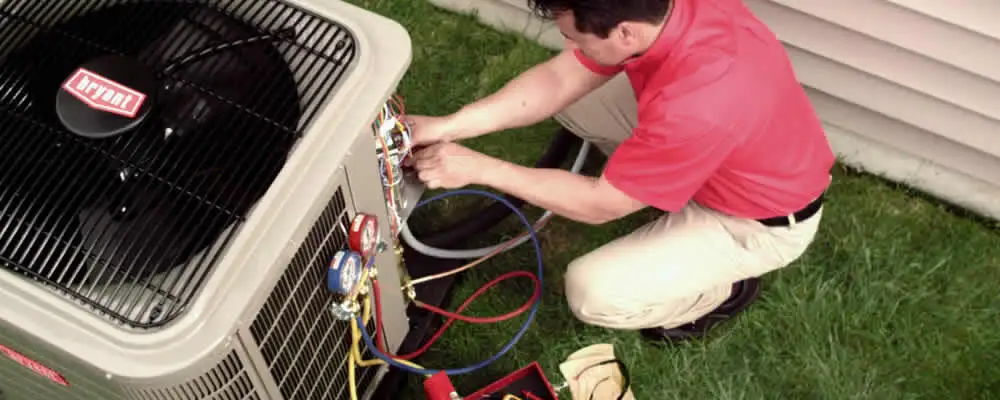 HVAC technician servicing an outdoor air conditioner unit in Madison, WI