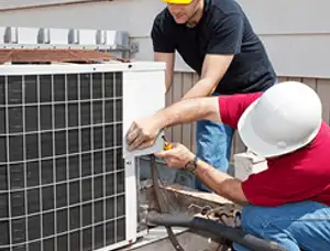 HVAC technicians repairing an outdoor AC unit on a rooftop in Madison, WI