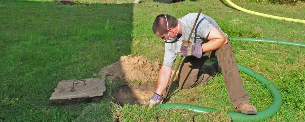 Septic pumping technician servicing a residential septic tank in Madison, WI