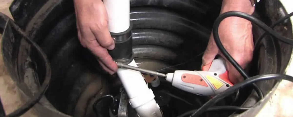 Sump pump installation technician connecting PVC discharge piping in Madison, WI
