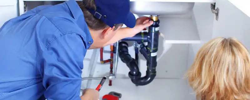 Plumber repairing under-sink drain pipes and fittings in Madison, WI